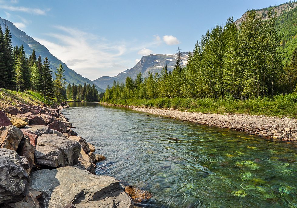_0012_GettyImages-1032239930 A river with trees and mountains in the background.