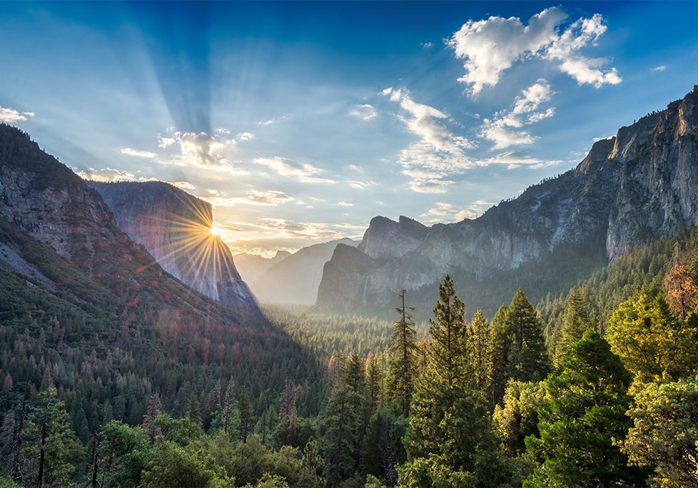 _0020_GettyImages-545090448 A view of the sun setting over mountains and trees.