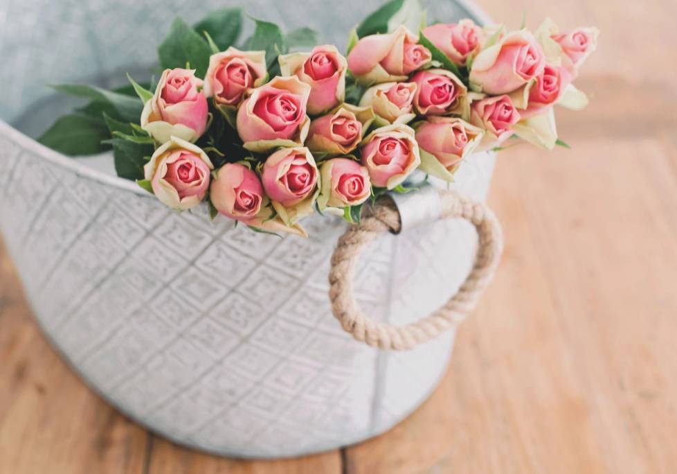 GettyImages-1283886803-1024x684-landscape-26cbdb8d6f1f792da877ec2b86940ef9- (2) A white basket with pink roses in it.