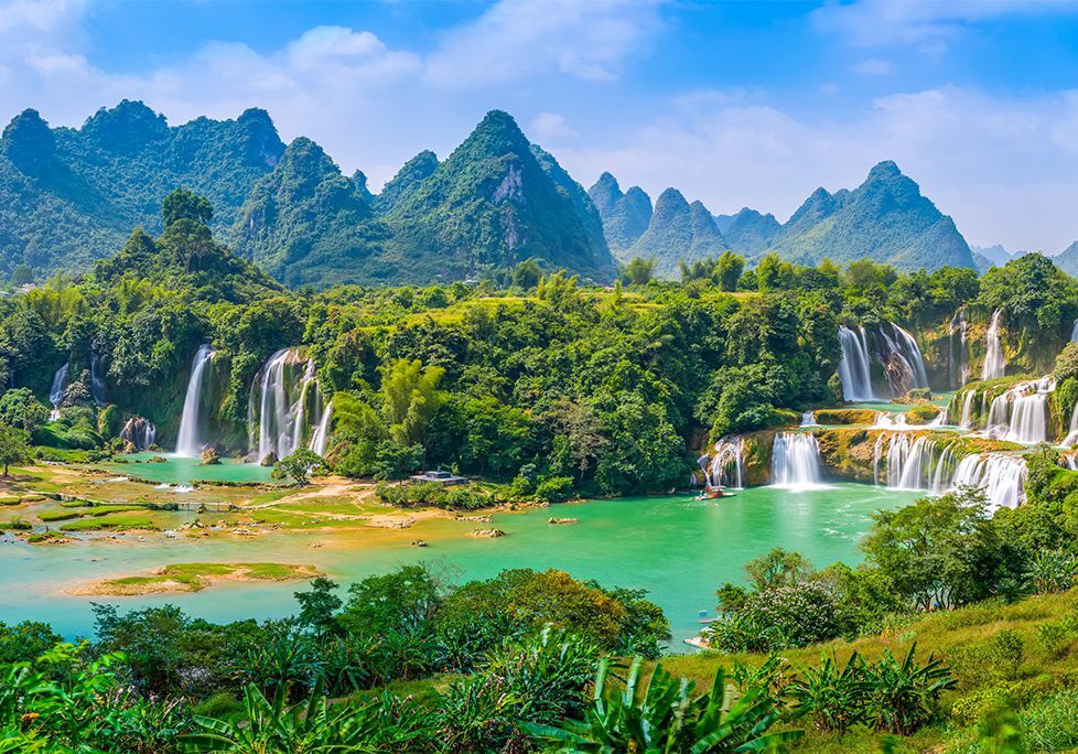 A beautiful view of some water falls and mountains.