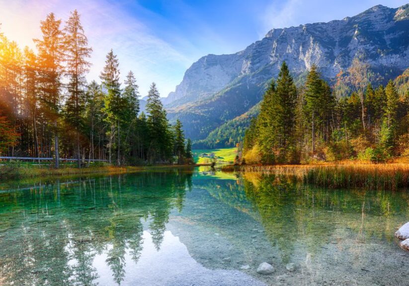 Mountain lake with trees and clear sky.